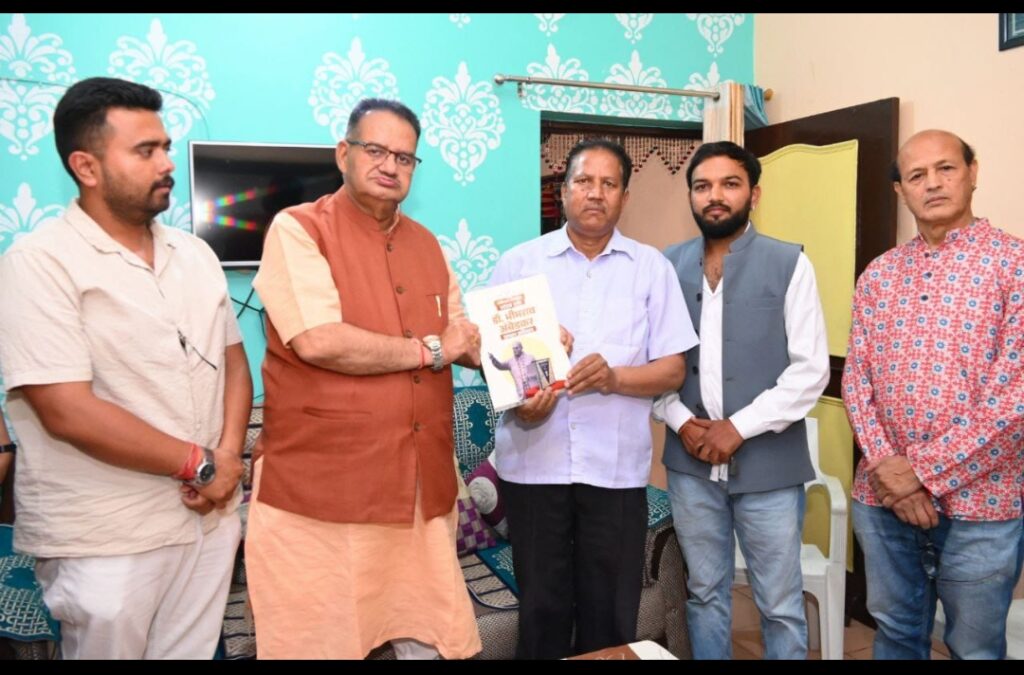 थानीगांव निवासी राजपाल सिंह को डा0 अम्बेडकर की जीवनी भेंट करते कैबिनेट मंत्री गणेश जोशी